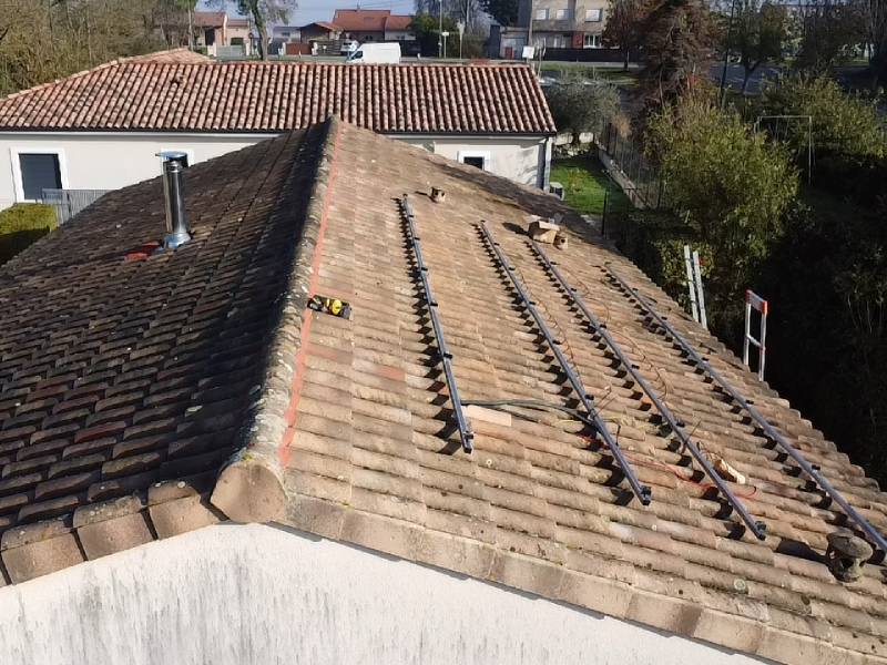 Pose en cours de l'ossature pour panneaux photovoltaïque sur le toit en tuiles à Lanta